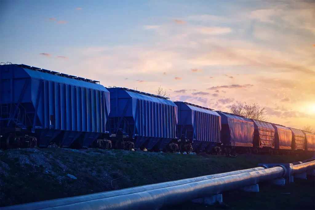 train-with-wagons-loaded-with-grain-moves-sunset-along-pipeline
